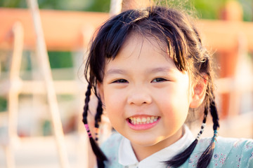 Wall Mural - Asian child girl playing on playground in outdoor park.Happy Little asian girl playing swing with her mother.Happy moment and good emotion.