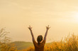 Asian woman standing in meadow and show hand up with love sign at sunrise time, Selective focus, Copy space.