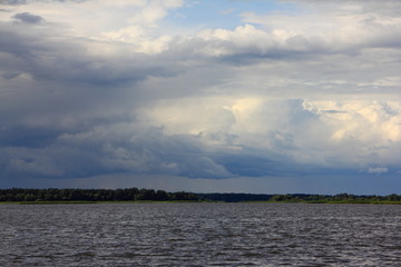 Wall Mural - Dramatic sky clouds over lake, river stormy landscape