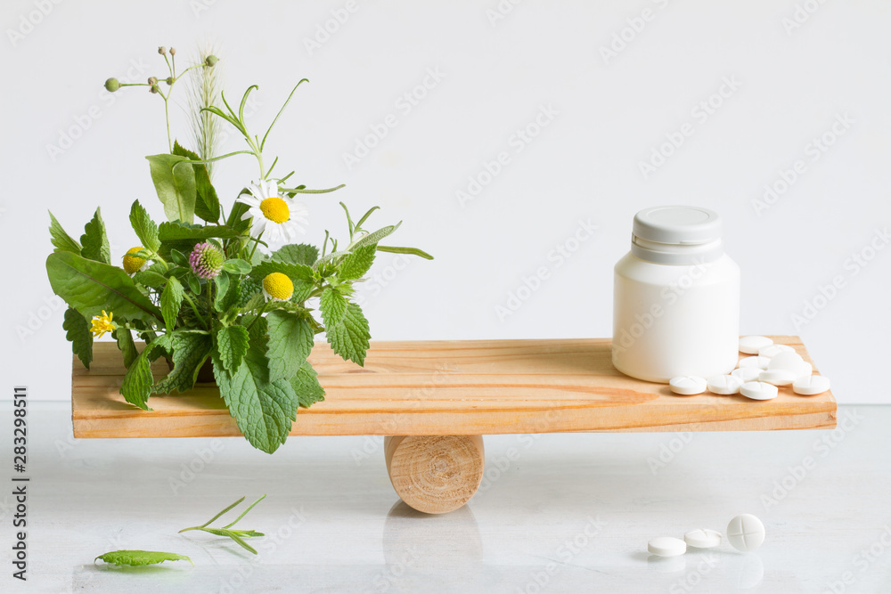 Alternative medicine or pills weight balance comparison with tablets and herbs - obrazy, fototapety, plakaty 