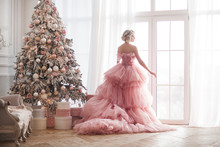Young Beautiful Blond Woman On Christmas Background Full Height. Attractive Lady In Pink Gorgeous Dress.