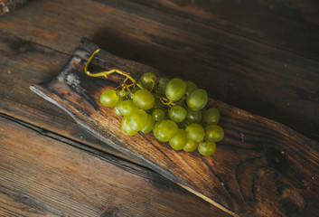 Sweet green grapes on wooden table.