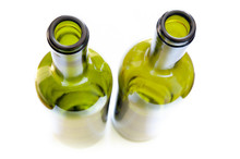 Top View, From Above, Of Green Glass Bottles With A Strong Selective Focus Effect, Isolated On White Background