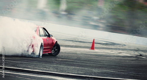 Cuadros en Lienzo Blurred of diffusion race drift car with lots of smoke from burning tires on speed track