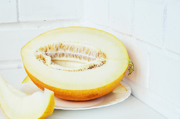 Ripe yellow melon on white background. Ripe yellow melon on a white table.