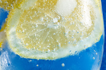 soda with lemon on blue macro