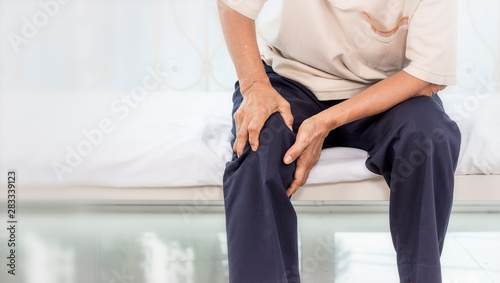 Cuadros en Lienzo Health problem concept; old woman suffering from knee pain at home