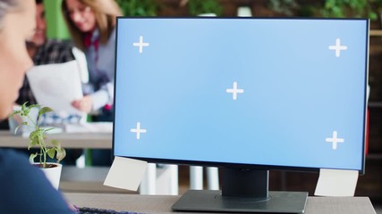 Caucasian business woman typing on her computer in the office. Mock-up display. Coworkers in the background.
