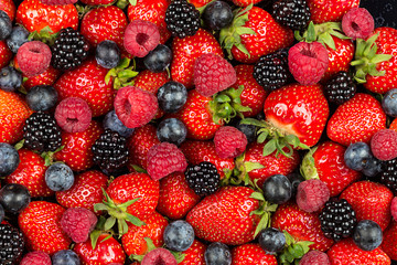 colorful tasty mix of wild forest berry fruits. Strawberry blueberry raspberry and blackberry. healthy eating nutrition vegan food concept background