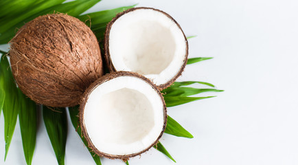 Ripe half cut coconut with green leaves on a white background. Isolated concept.