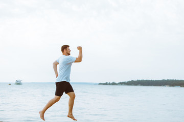 Wall Mural - man running by sea beach barefoot