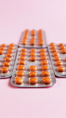 Wall Mural - Several blisters with medicine pills on pink background. Rows of tablets, capsules. Dietary supplement, health care and treatment. Pharmaceutical industry concept. Copyspace for text. Vertical photo