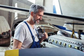 Aircraft maintenance mechanic inspects  plane engine