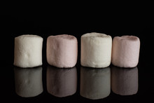 Group Of Four Whole Sweet Fluffy Marshmallow Isolated On Black Glass