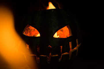 green watermelon burns with fiery flame on the scary holiday of october halloween