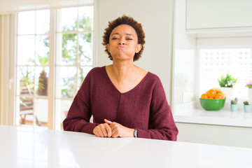 Sticker - Young beautiful african american woman at home puffing cheeks with funny face. Mouth inflated with air, crazy expression.