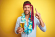 © Krakenimages.com - Hangover business man drunk and crazy for hangover wearing tie on head drinking beer surprised with an idea or question pointing finger with happy face, number one