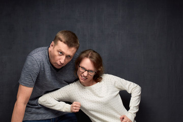 Wall Mural - Furious woman is beating man grimacing and crouching from pain