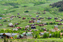 Mount Crested Butte Village Town In Summer With Colorful Grass And Many Wooden Lodging Houses On Hills With Green Lush Color