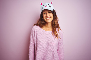 Young beautiful woman wearing funny cat cap standing over pink isolated background with a happy and cool smile on face. Lucky person.