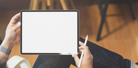 Freelancer working on his project with blank screen tablet