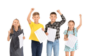 Wall Mural - Happy children with answer sheets for school test on white background