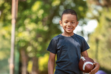 Cute Little African-American Boy With Rugby Ball In Park
