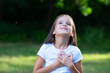 © Khorzhevska - Little girl looking up to at sky with hands on chest, summer nature outdoor. Happy smiling kid feels grateful, wishes dream come true