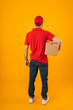 © Drobot Dean - Full length portrait from back of young delivery man in red uniform holding packaging box