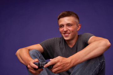 teen playing video games. young man sitting m joystick in his hands.