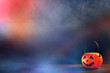 Halloween concept - Orange plastic pumpkin lantern on a dark wooden table with blurry sparkling light in the background, trick or treat, close up.