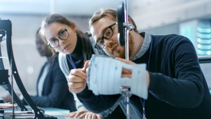 Wall Mural - young talented male and female engineers in a modern laboratory construct prototype with the help of