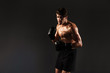 © Drobot Dean - Handsome young strong sportsman boxer in gloves make exercises boxing isolated over black wall background.