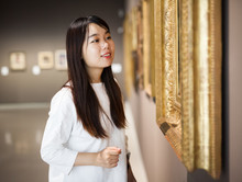Chinese Woman Standing In Art Museum Near The Painting