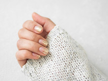 Manicure Salon Concept. Beautiful Women Hands With Golden Nail Manicure On A White Background. Gold Nail Polish. Closeup