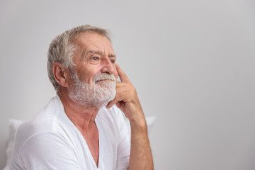 Wall Mural - Senior elderly man sitting on bed and try to remember after waking up in morning