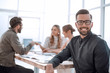 © ASDF - smiling businessman in the background of the office.