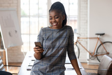 Happy African American Business Woman Using Smartphone In Modern Office
