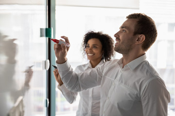 Wall Mural - Diverse colleagues writing on flip chart, working on business strategy