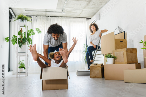 Fotografía Happy playful African American family moving in new apartment, little preschool
