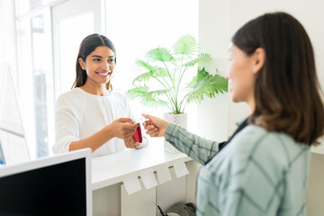 Client Paying For Beauty Treatment To Receptionist In Spa