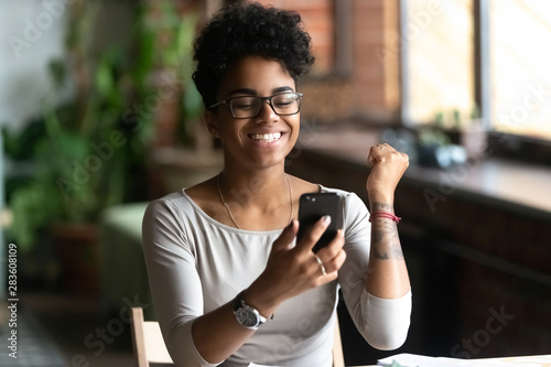 Fotografía Excited black girl feel euphoric reading news on cell