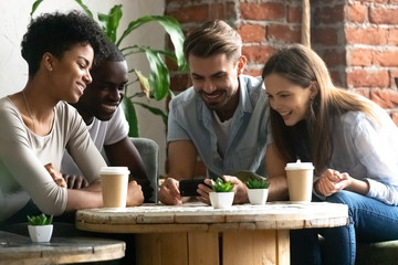 Happy diverse people watch funny video on cellphone