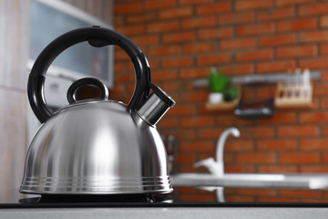 Wall Mural - Modern kettle with whistle on stove in kitchen, space for text