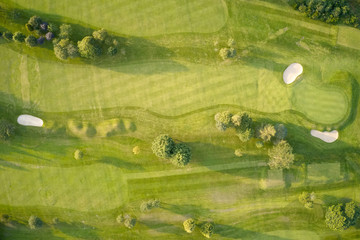 Aerial view of links golf course during summer showing green and bunkers at driving range