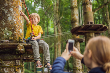 Little boy in a rope park. Active physical recreation of the child in the fresh air in the park. Training for children