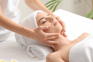 Canvas Print - Young woman having facial massage in beauty salon