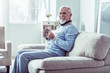 © zinkevych - Beaming retired man wearing jeans and blue sweater drinking some tea