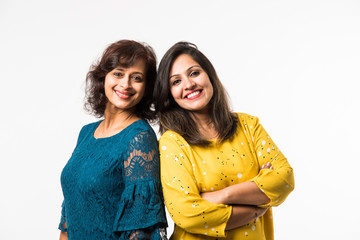 Beautiful mother and adult daughter  hugging and smiling while standing isolated over white background