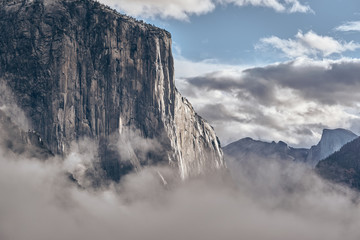 Wall Mural - El Capitan rock close-up in Yosemite National Park Valley at cloudy autumn morning from Tunnel View. Low clouds lay in the valley. California, USA.